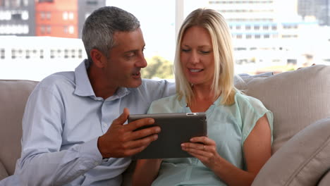 una pareja feliz usando una tableta juntos.