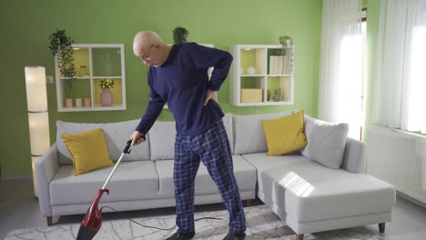 Old-man-cleaning-house-gets-tired-while-using-vacuum-cleaner.