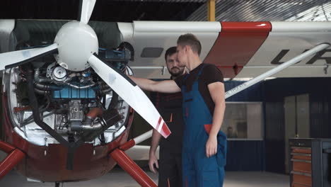 aircraft mechanics inspecting an airplane engine in a hangar