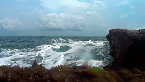 slow motion low angle view of wave splashing against reefs in the caribbean, tortuguilla, colon, panama