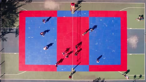 top down aerial view of people playing volleyball game on colorful outdoor court