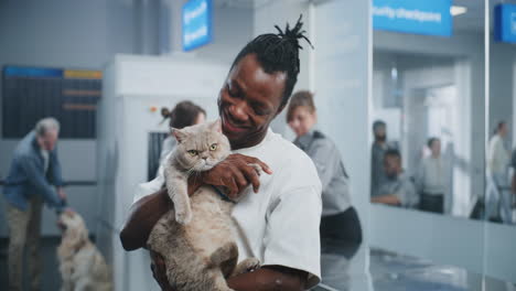 man holding a cat at the airport