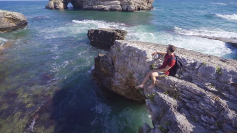 Young-man-sitting-on-the-cliff.