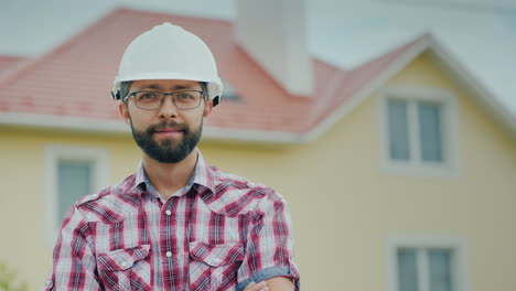 Portrait-Of-A-Brigade-In-A-Helmet-On-The-Background-Of-A-Modern-Cottage-Professional-In-Building-A-C