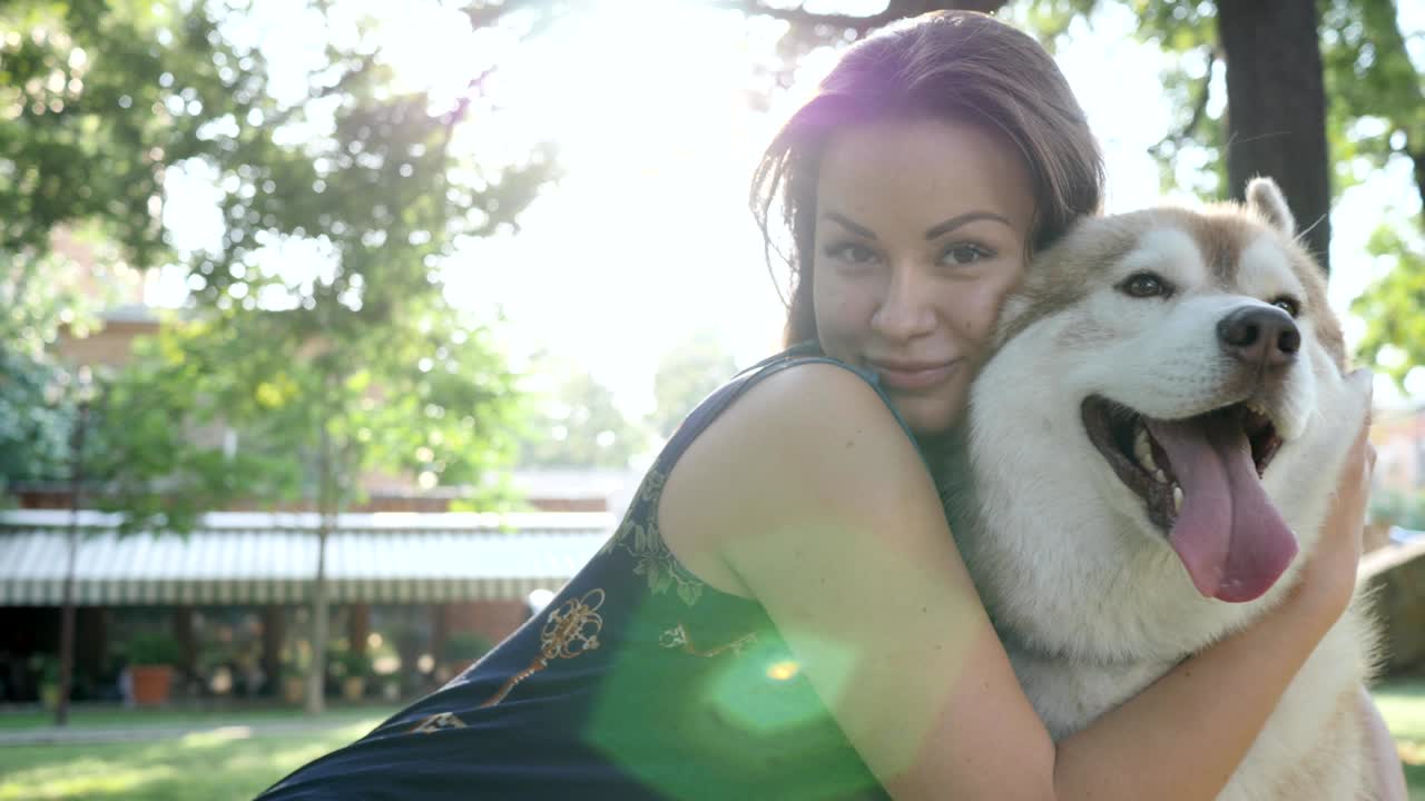 젊은 여성이 미소 짓고 허스키 개를 안고 공원에서 클로즈업, 행복한 애완동물 호스트 근처에서 재미