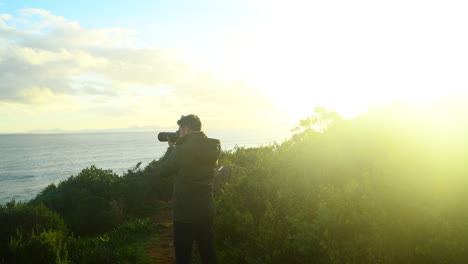 a young man taking a photo using a dslr camera