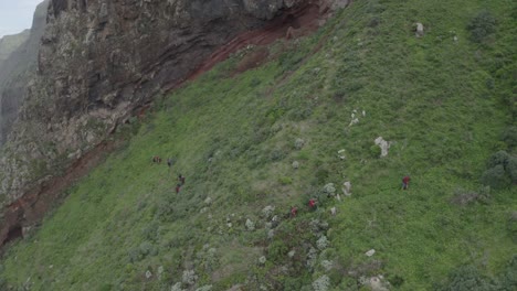 un gran grupo de personas está caminando por el borde de la montaña quebrada do negro en madeira