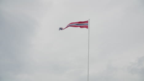 norwegian pennant waving in the wind at coastal battery