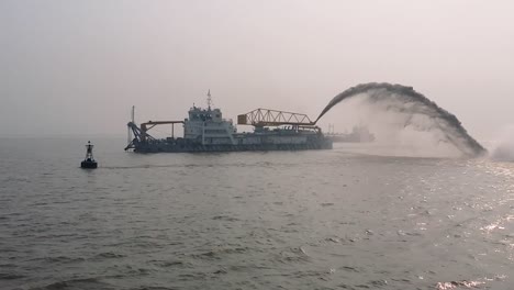 dredging vessel in action to keep waterways navigable, excavate and gathering sediments in the bottom and disposing at another location, close up b roll video clip