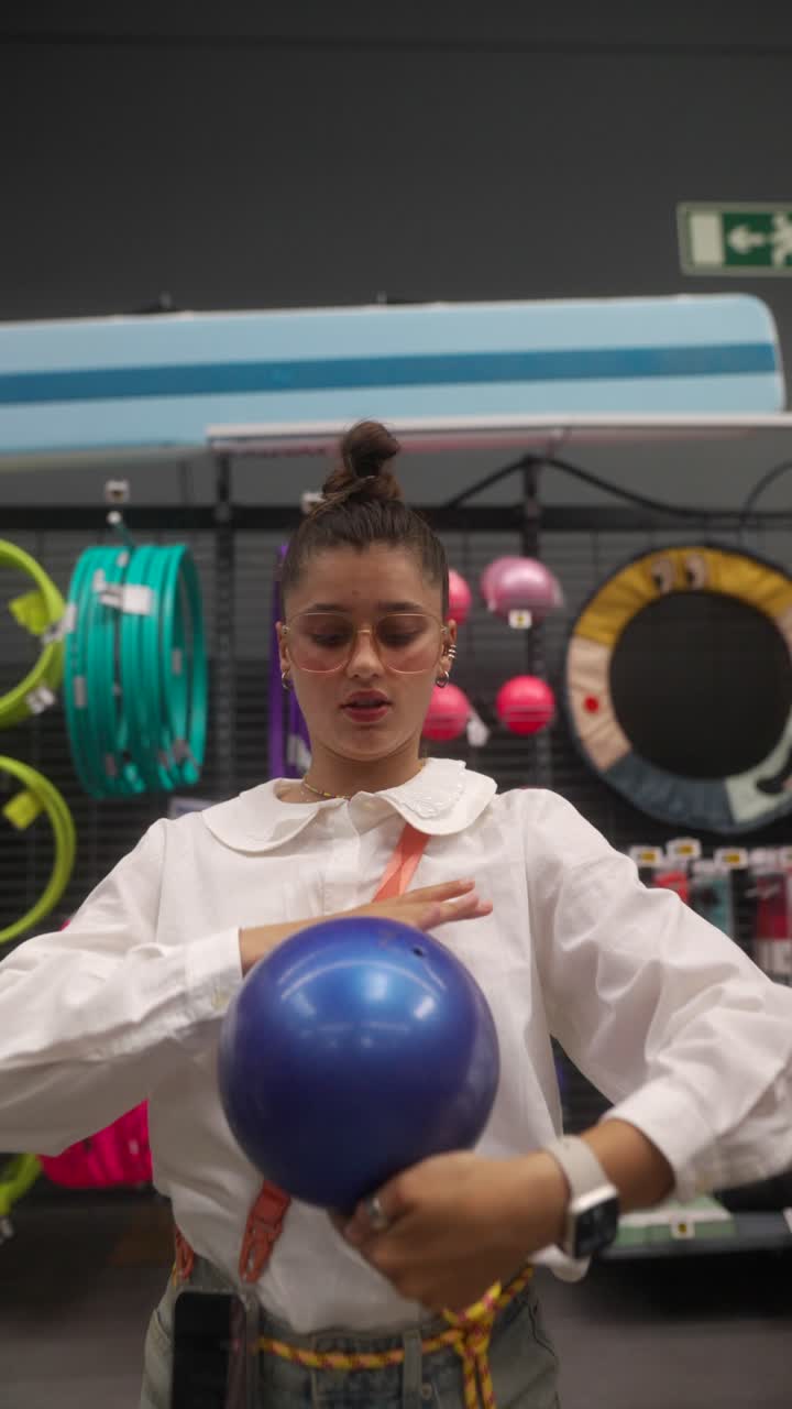Woman holding a blue exercise ball in a store