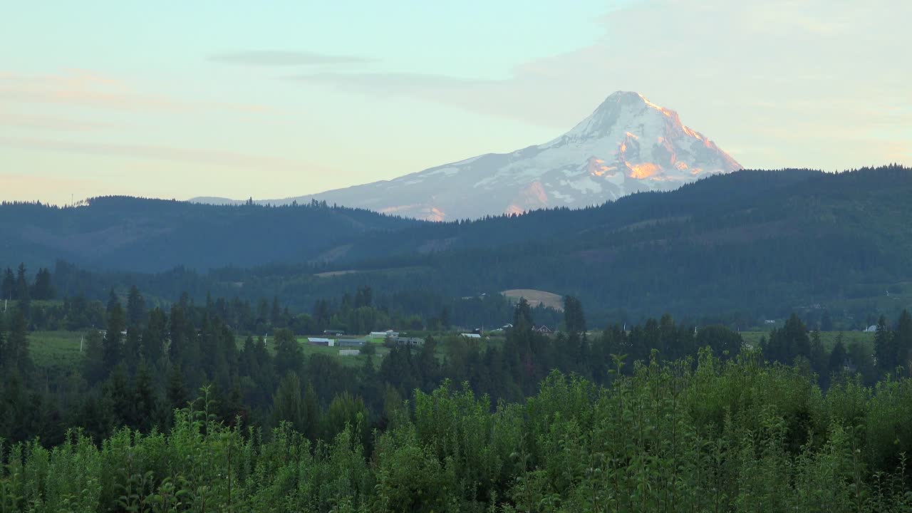 luz del atardecer en mt hood cerca del río hood oregon con granjas y campos en primer plano