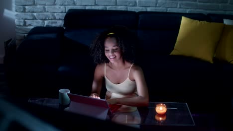 young latina woman typing message on laptop at night