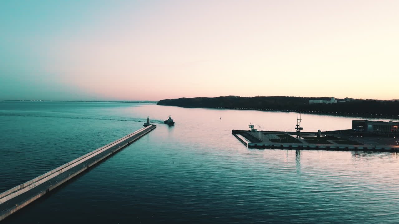drone volando al barco militar navegando a la bahía al atardecer