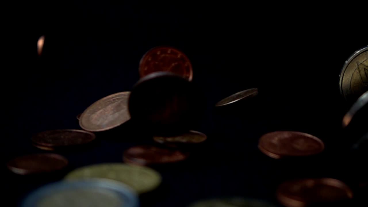 Monete cadono su uno sfondo nero. Movimento lento