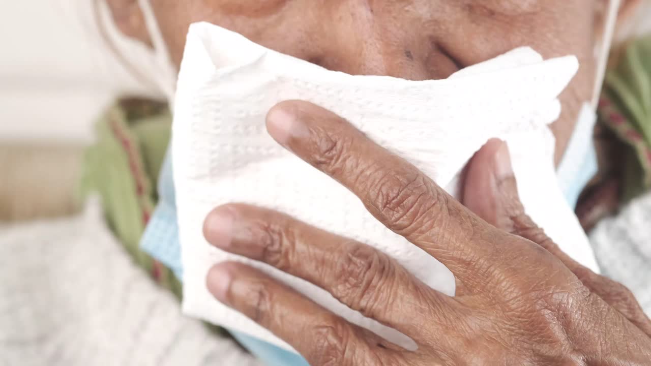 Elderly person with tissue and face mask
