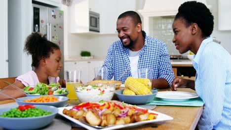 Family-having-meal-on-dinning-table-at-home