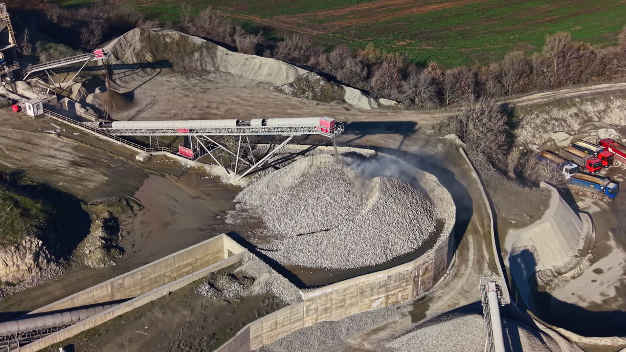 Natural resources extraction in a vast quarry site showcasing machinery and material movement in a magnificent landscape during bright daylight