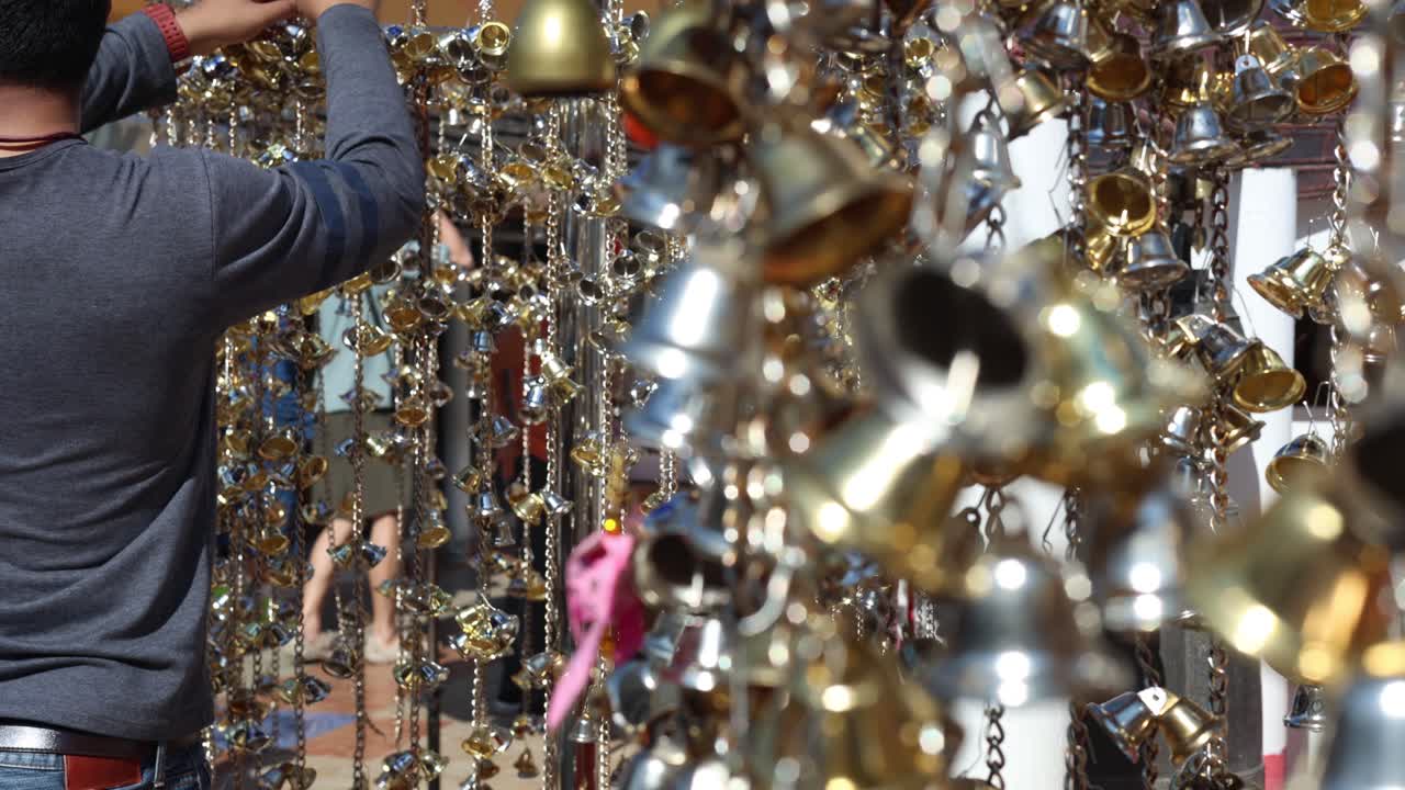 Person adding bells to an outdoor installation