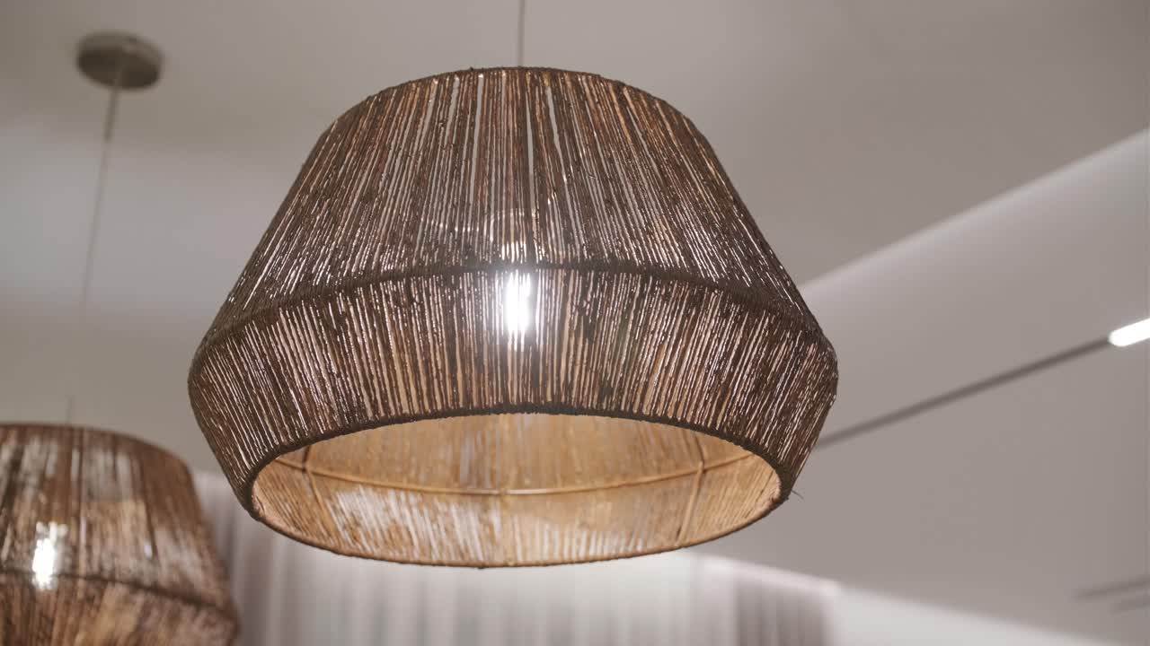 fotografía de cerca de una lámpara de lámpara de mimbre decorativa colgada en el techo en un café moderno o un gastro pub. interior de diseñador auténtico en un restaurante. decoración elegante en lugares de catering público. iluminación interior.