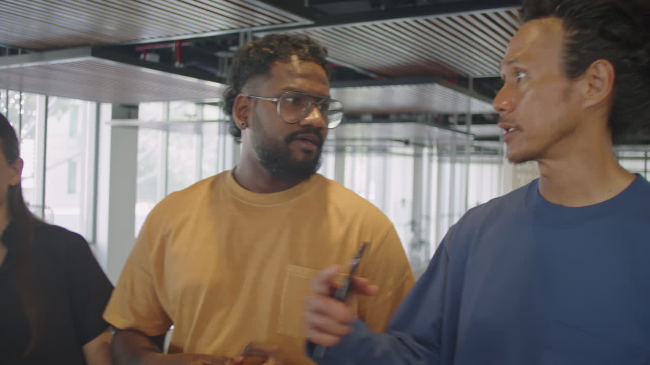 Male Colleagues Walking in Office and Chatting