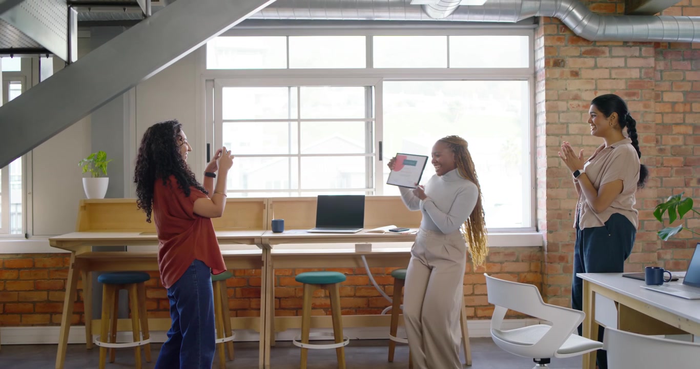 Diverse women at work coworker handing framed cert red graphic center posing for phone celebrating