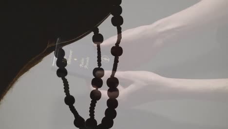 Animation-of-caucasian-woman-reading-bible-over-hands-with-rosary