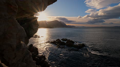 beautiful sunrise view over ocean and mountain in hermanus from sea cliff