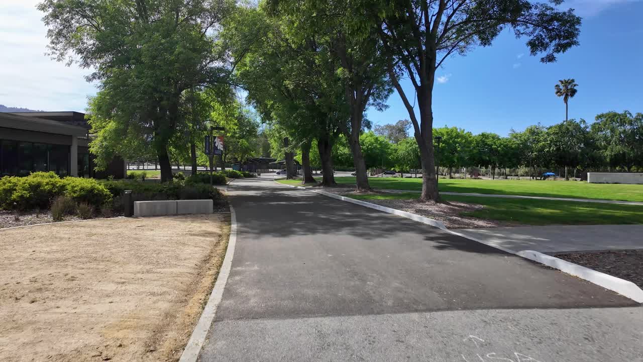 First-person perspective walking along a paved pathway through the beautiful and tree-lined campus of West Valley College in Saratoga, California on a sunny day