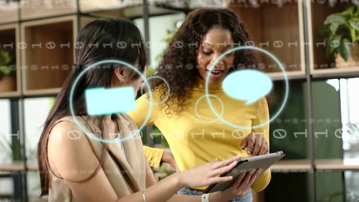 Two women tapping tablet and pointing causing overlay mail icon animating then clearing for ads