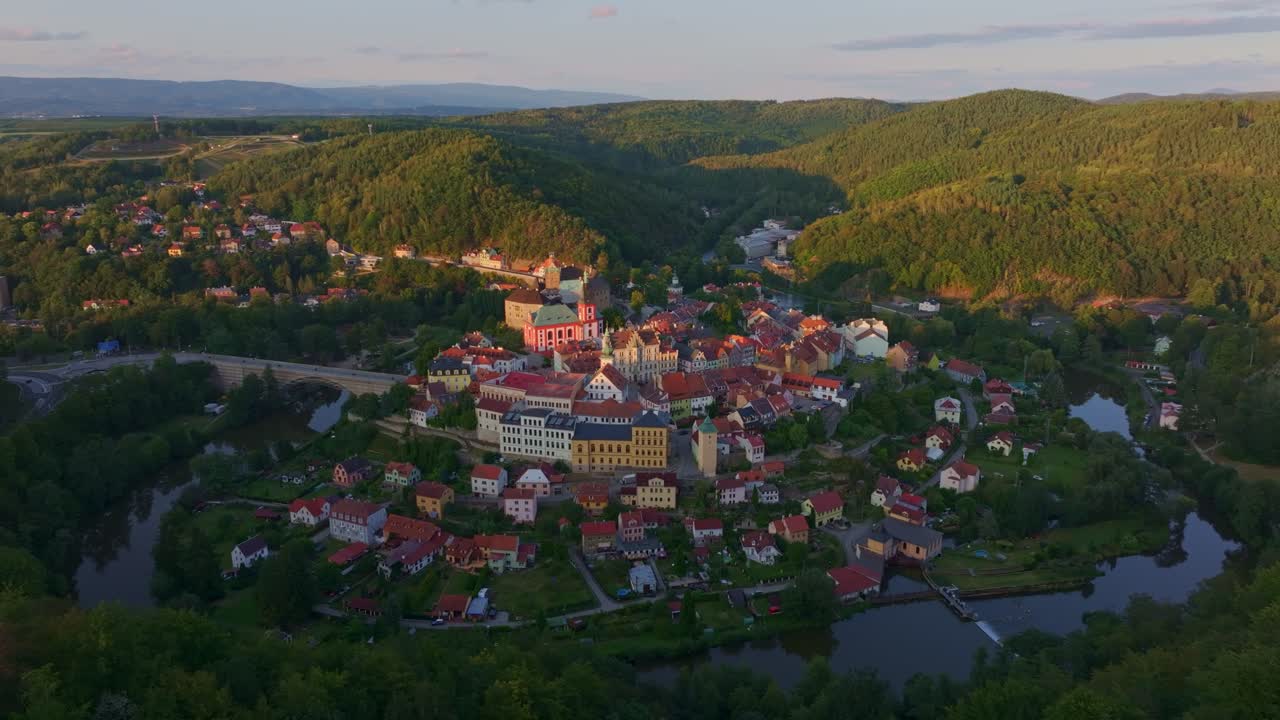 Malerisches Dorf Loket und Fluss Eger, umrahmt von Bergen bei Sonnenuntergang, Tschechien.