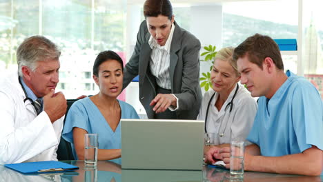 Equipo-Médico-Mirando-La-Computadora-Portátil-Durante-La-Reunión-