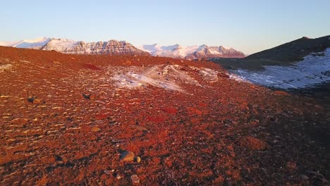 Filmische-Eröffnungssequenz-In-Island-über-Warm-Beleuchteten,-Sonnenbeschienenen-Felsen,-Um-Gletschereisberge-Zu-Enthüllen,-Die-Im-See-Schwimmen,-Bergiger-Hintergrund