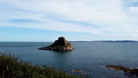 time lapse shot showing thatcher rock in ocean seaside during cloudy and sunny day