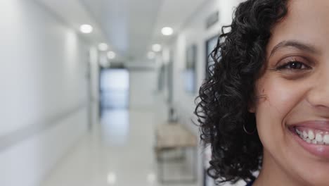 Portrait-of-happy-biracial-female-doctor-in-hospital-in-slow-motion