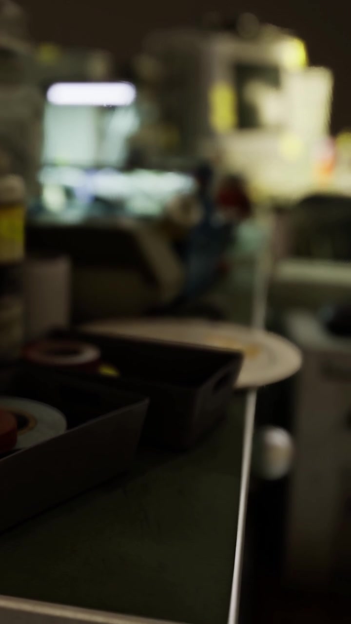 Spazio di lavoro affollato con attrezzi e materiali in un'officina nelle ore serali.