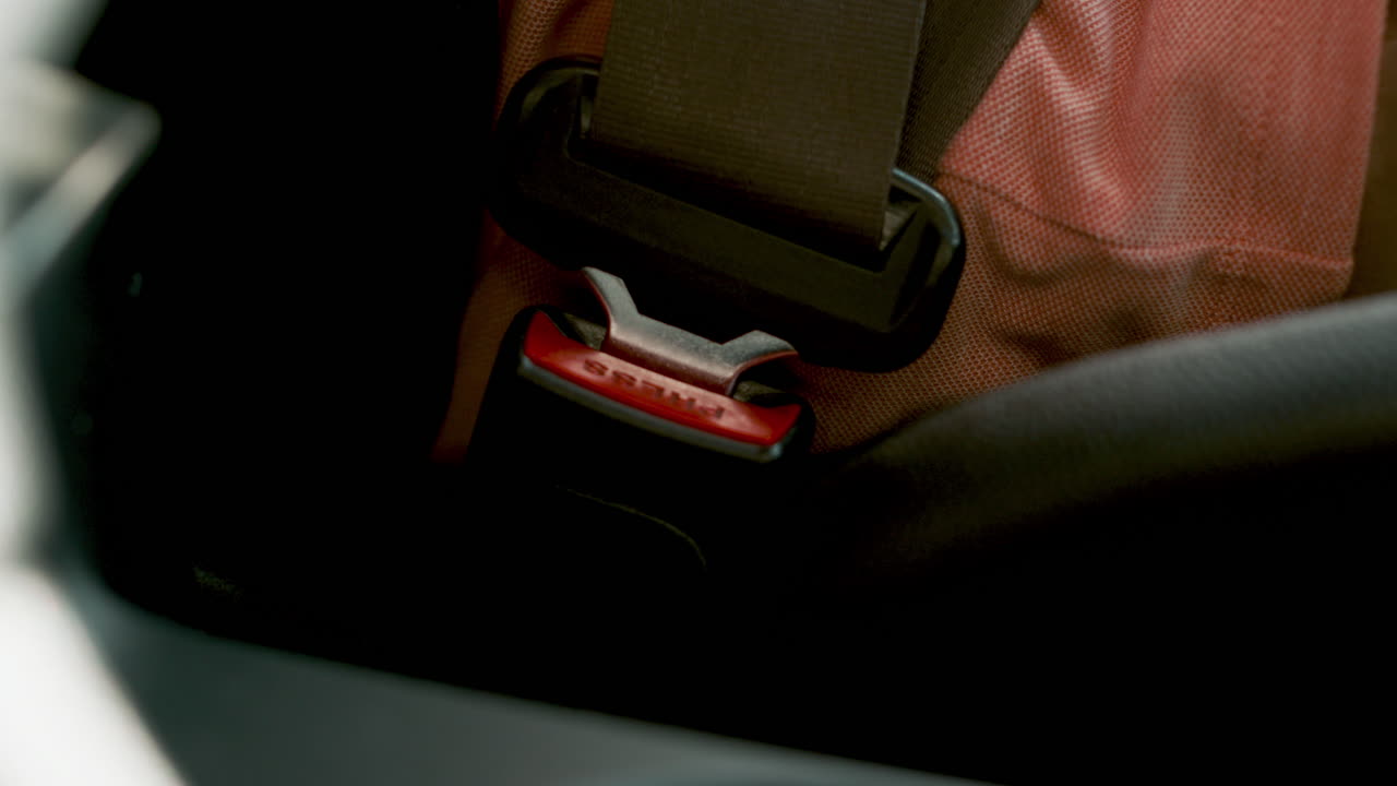 человек снимает ремень безопасности.