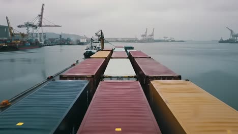 container ship navigating through a busy port with cranes and tranquil waters in the background, showcasing maritime and shipping activities