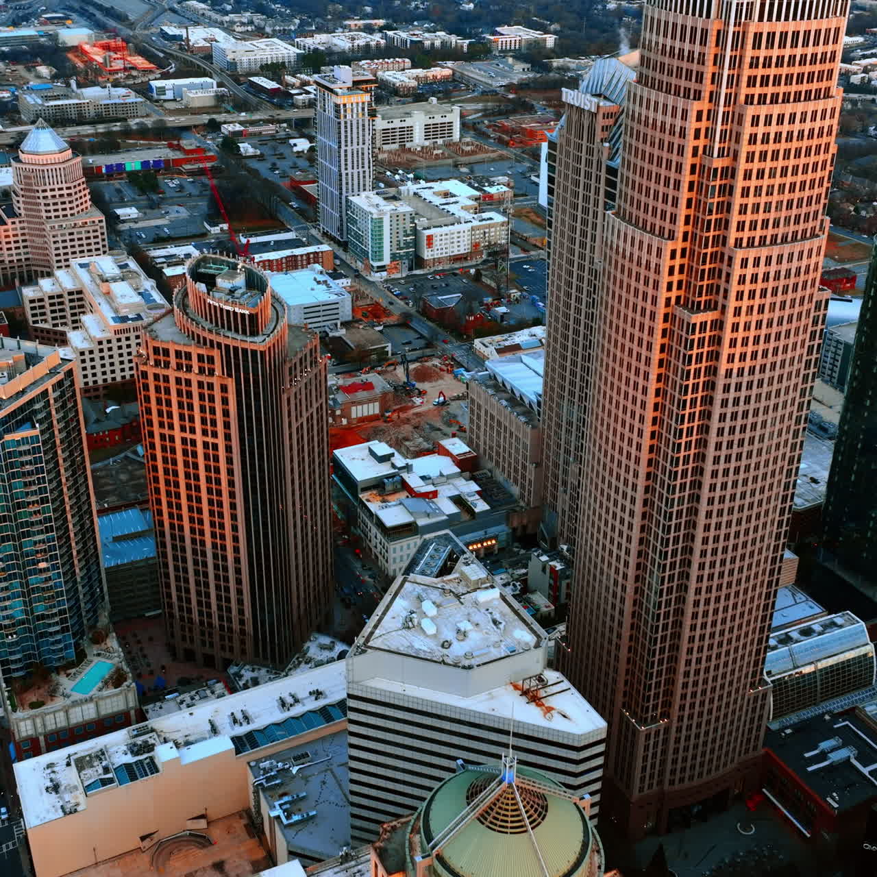 Panoramic view on the diverse architecture in the downtown of Charlotte, North Carolina, USA. Cityscape in the rays of setting sun from top.