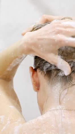 a woman washes her hair with shampoo