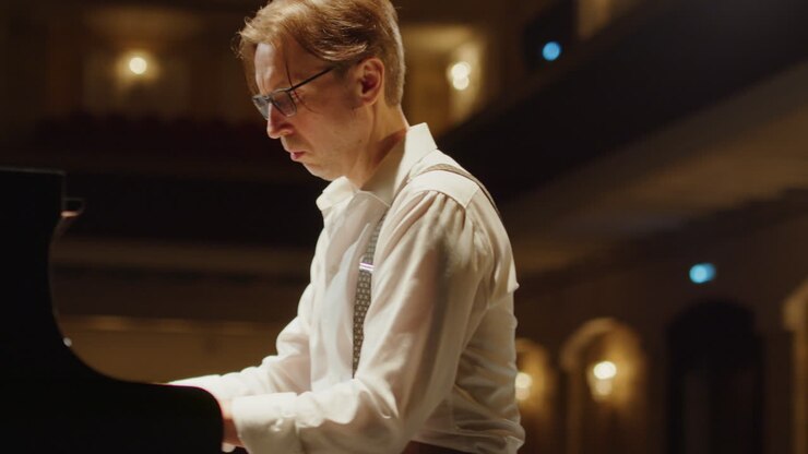 Pianist Playing Grand Piano in Concert Hall