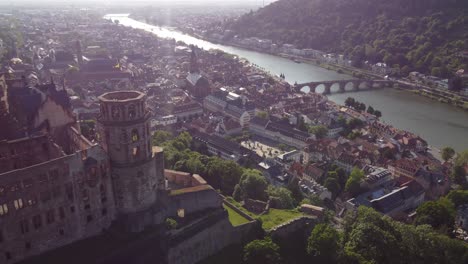 Cinematic-aerial-Reveal-of-Heidelberg-Castle-and-city-center-on-a-sunny-day-at-sunset,-Germany