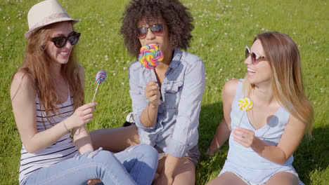 tres mujeres lamiendo piruletas