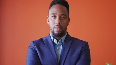 video of smiling african american man looking at camera on orange background