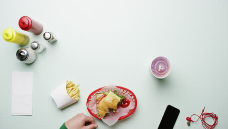 top view man eating burger at american diner fast food restaurant hands from above - red epic dragon