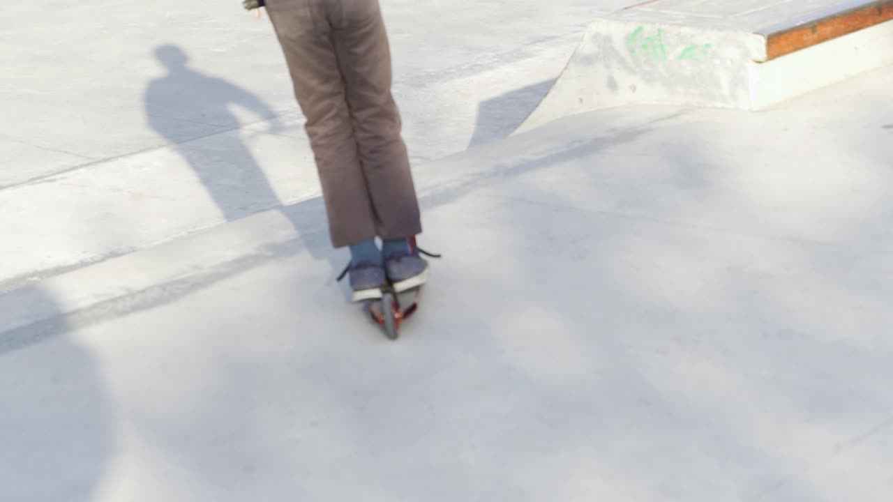 trucos de scooter en el parque de patinaje