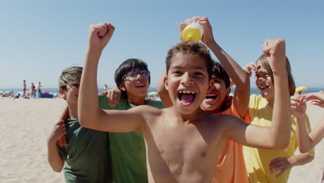 vista frontal de los niños felices swilling líder del equipo de fútbol