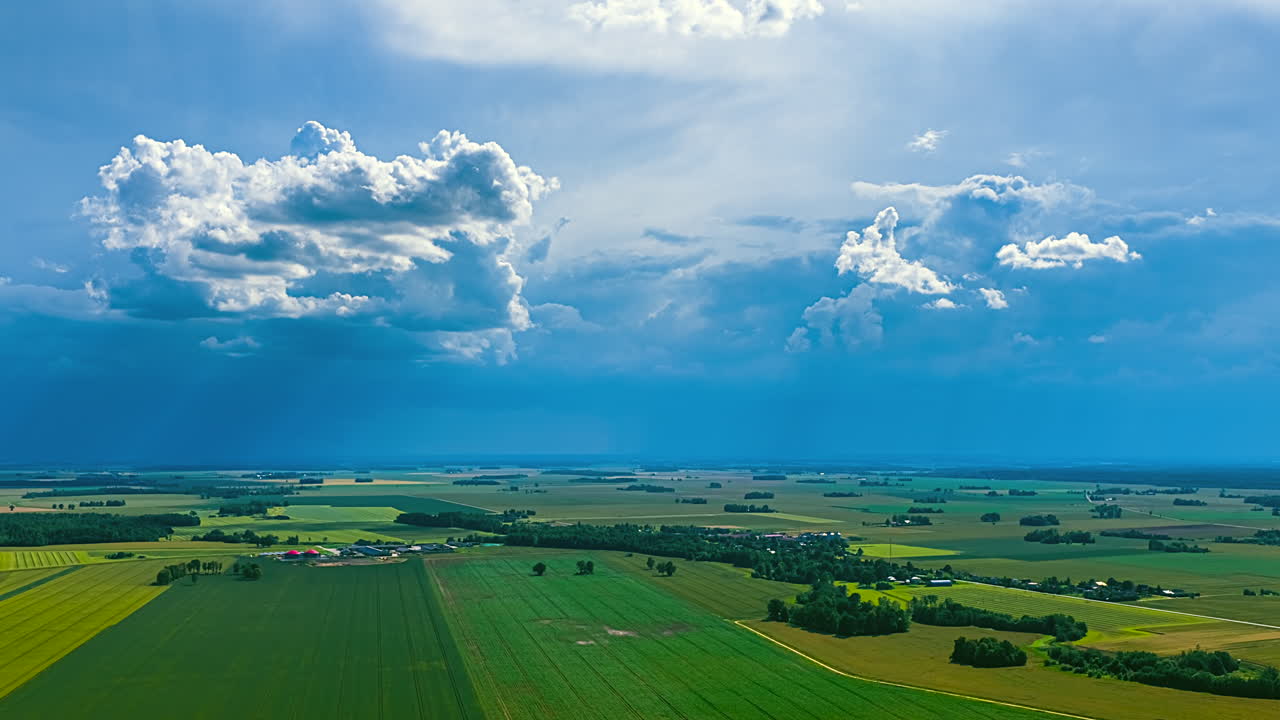 Stormy sky and clouds moving over green agricultural field. Time lapse