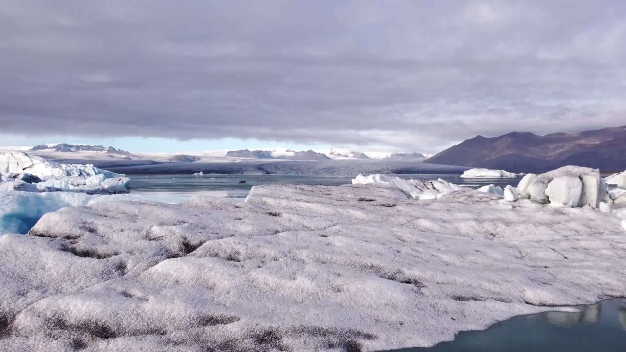 An breathtaking aerial perspective captures the serene yet dynamic beauty of Jökulsárlón, Iceland's famous glacial lagoon