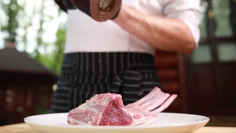 cocinero sazonando las costillas de cordero