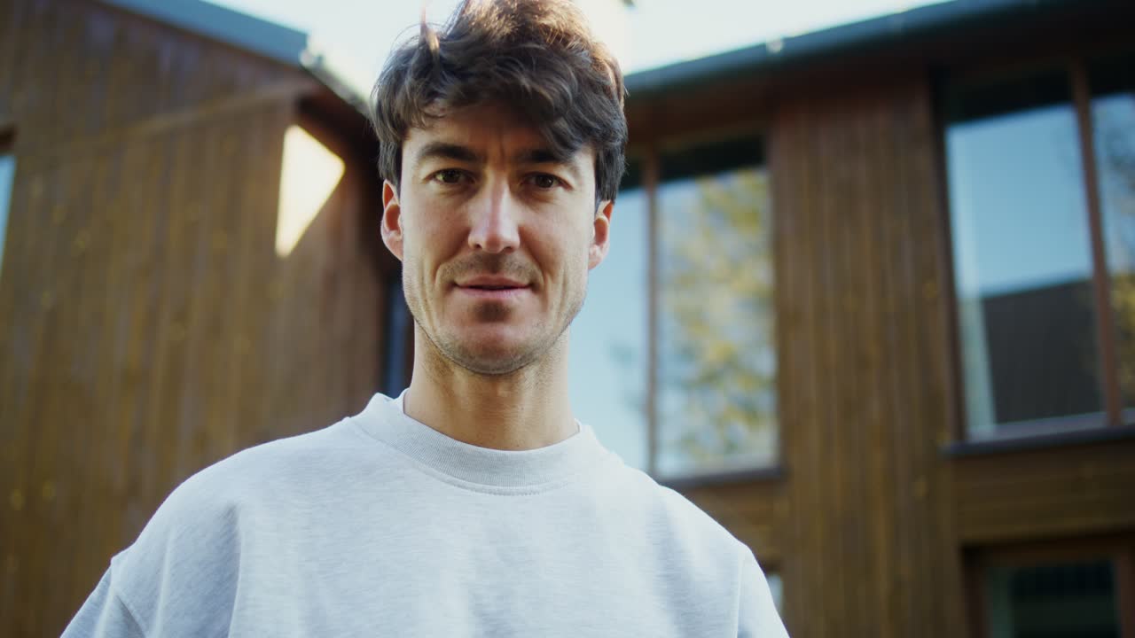 hombre frente a una casa de madera